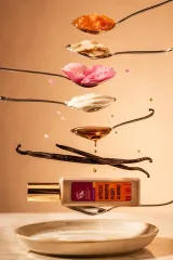 Долоня з флаконом Apricot Whisper на тлі вовняного пальта, шовкового шарфа і темної шкіряної сумки — фруктово-пряний шлейф у прохолодному осінньому повітрі