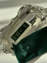 Натюрморт при холодному світлі: флакон Herbal Skin, гілки зелені й шматок сірої амбри на світлому камені