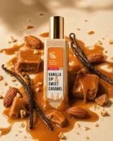 Натюрморт при теплому світлі: флакон Vanilla Sip, розплавлена карамель у керамічній ложці, червоні ягоди барбарису в скляній вазочці і стручок ванілі на бежевому камені